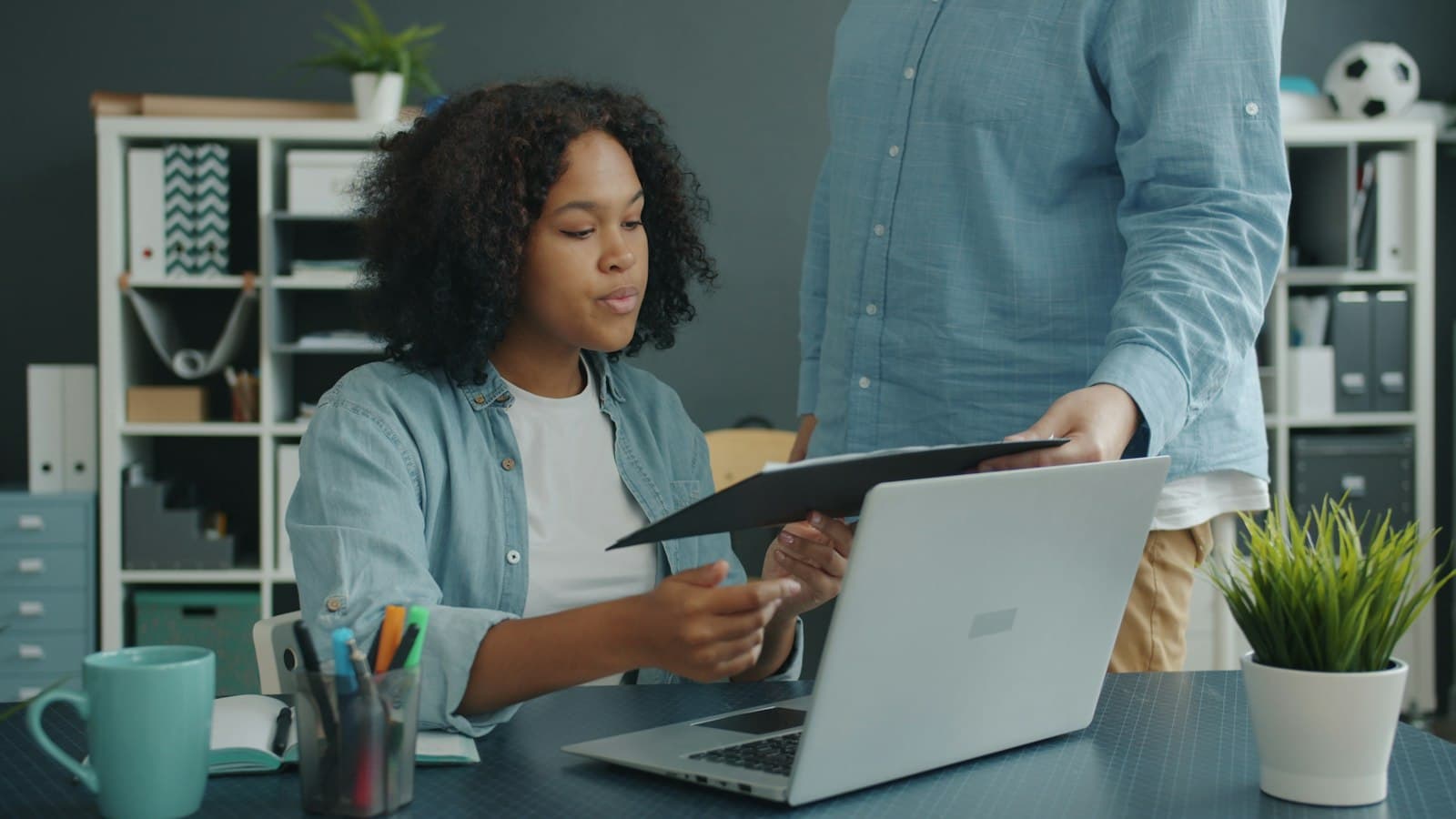 Two colleagues going over paperwork together at an office desk